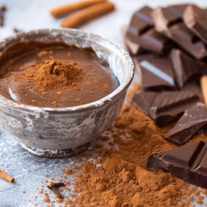 Mexican spice dipping sauce. A cup of chocolate spice infused dipping sauce with chucks of chocolate and cinnamon around it